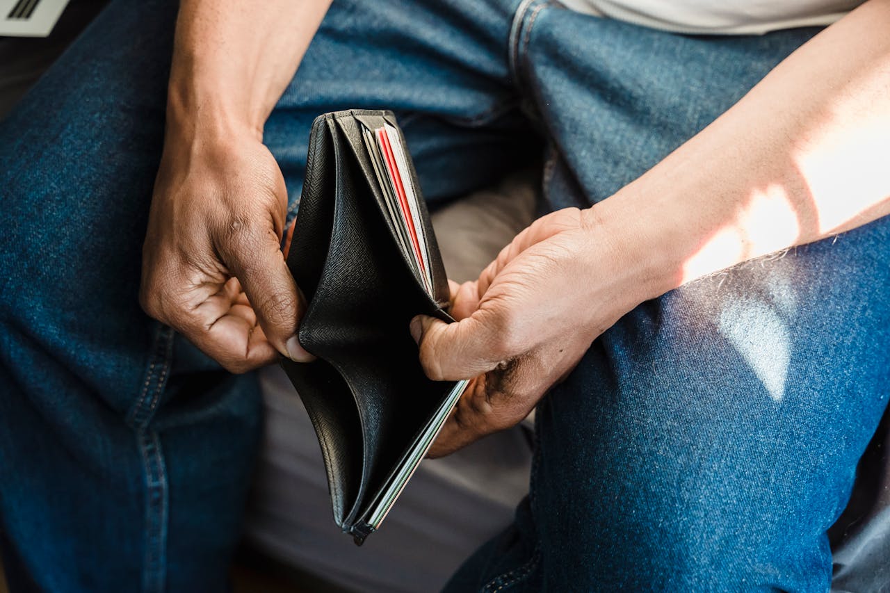 services-03 Close-up of a man holding an empty wallet, symbolizing financial crisis and hardship.